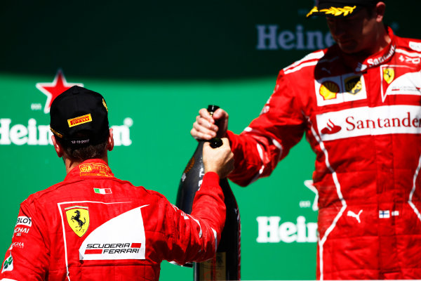 Interlagos, Sao Paulo, Brazil.
Sunday 12 November 2017.
Winner Sebastian Vettel, Ferrari, 1st Position, and Kimi Raikkonen, Ferrari, 3rd position, with their champagne on the podium.
World Copyright: Andy Hone/LAT Images 
ref: Digital Image _ONZ6974