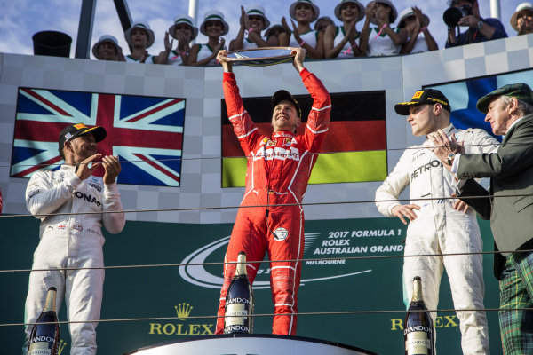 Lewis Hamilton (GBR) Mercedes AMG F1, race winner Sebastian Vettel (GER) Ferrari and Valtteri Bottas (FIN) Mercedes AMG F1 celebrate on the podium with the trophy at Formula One World Championship, Rd1, Australian Grand Prix, Race, Albert Park, Melbourne, Australia, Sunday 26 March 2017.