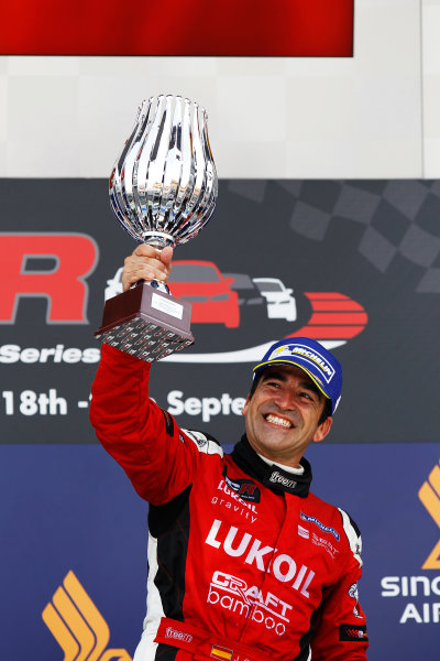 2015 TCR International Series Round 9.
Marina Bay Circuit, Singapore.
Sunday 20 September 2015.
Jordi Gene, No.88 Team Craft-Bamboo LUKOIL, lifts his trophy on the podium.
World Copyright: Sam Bloxham/LAT Photographic.
ref: Digital Image _G7C4006